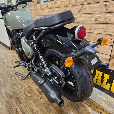 Black motorcycle with orange reflectors on a wooden floor