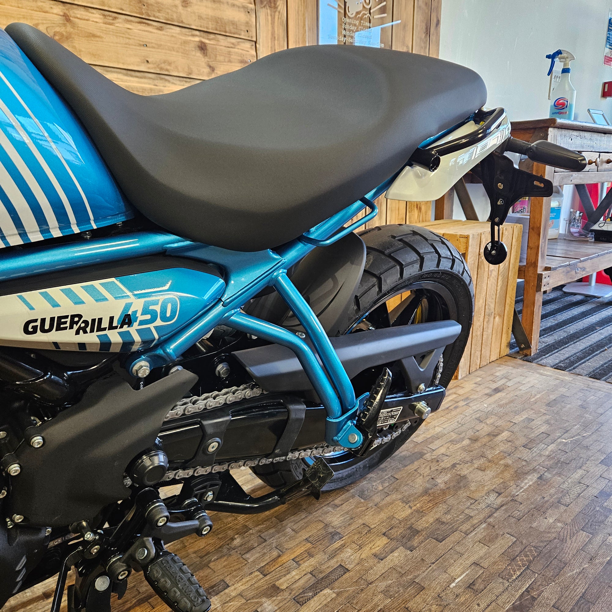 Motorcycle with 'Guerrilla' branding on a wooden floor.