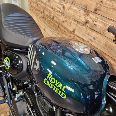 Motorcycle with 'Royal Enfield' branding on a wooden floor background