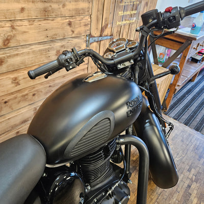 Black motorcycle on a wooden floor with a blurred background