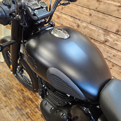 Close-up of a black motorcycle on a wooden floor