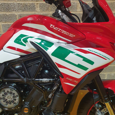 Close-up of a red motorcycle with visible branding on a textured surface