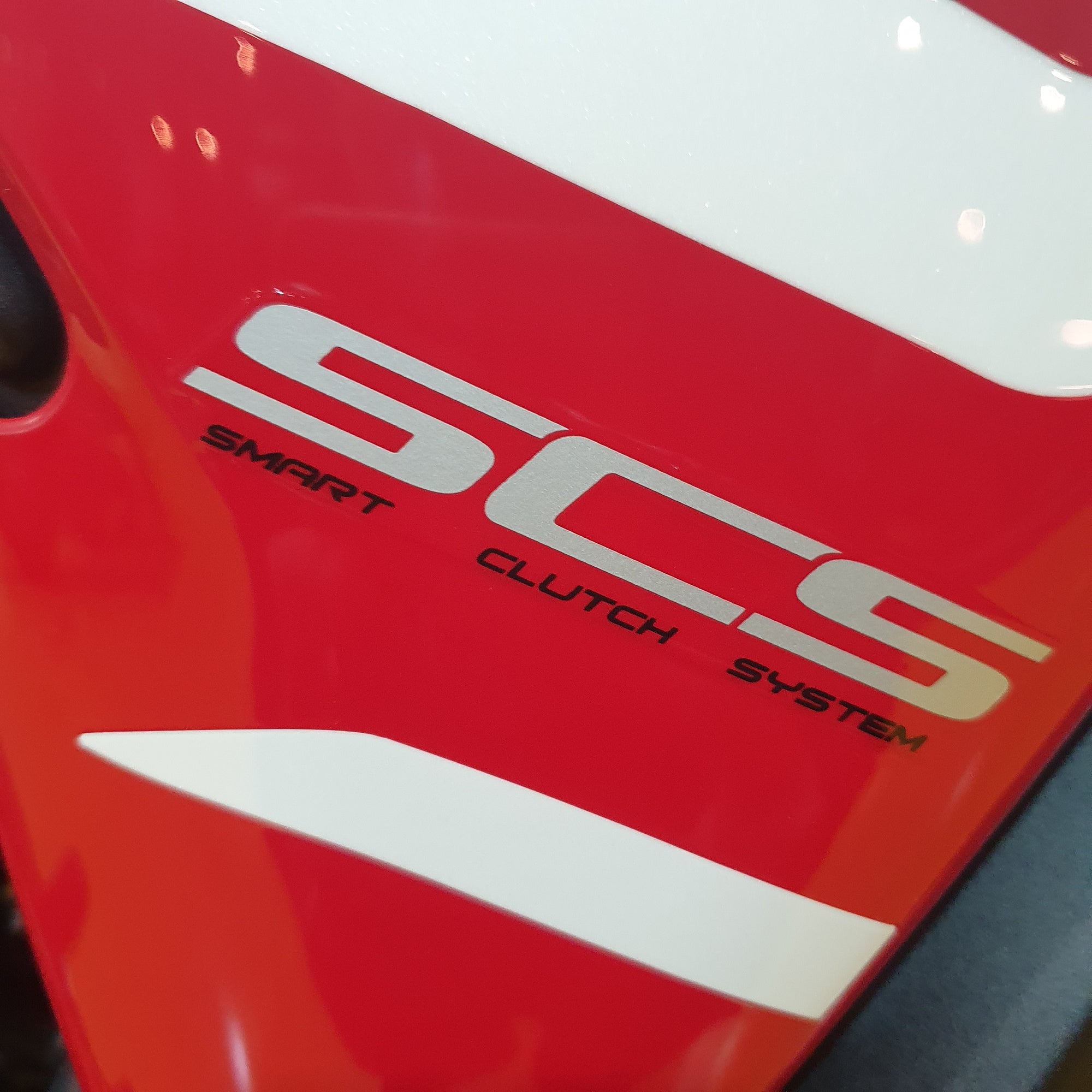 Close-up of a red and white vehicle with 'SCS' branding on a blurred background