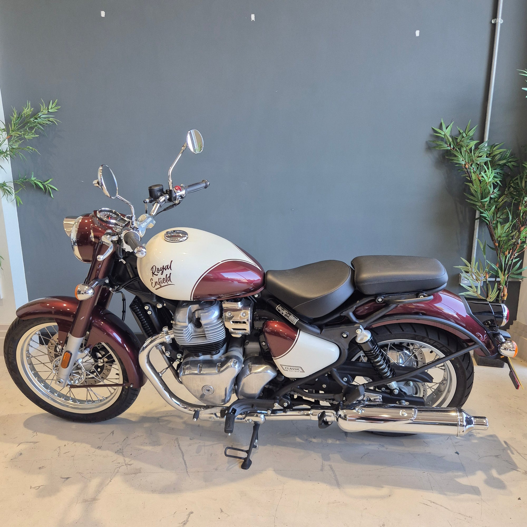 Motorcycle mounted vertically on a wall with a neutral background