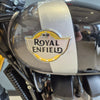 Close-up of a Royal Enfield motorcycle headlight with the brand logo.