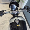 Close-up of a motorcycle's handlebar and front section with a blurred background