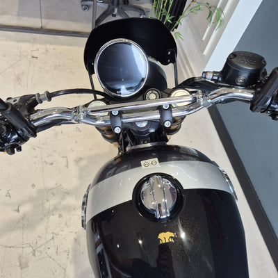 Close-up of a motorcycle's handlebar and front section with a blurred background