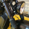 Close-up of a motorcycle headlight and handlebar on a yellow background