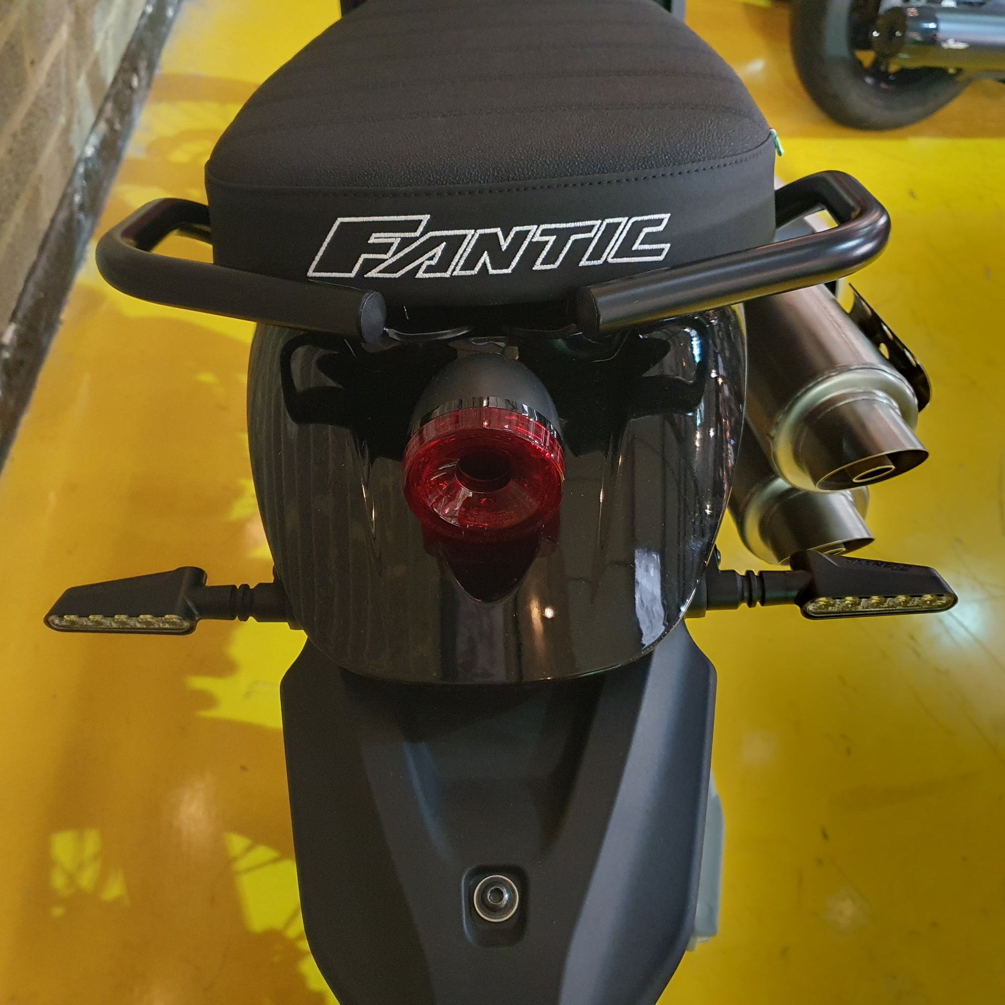 Close-up of a scooter with 'Fantic' branding on a yellow background