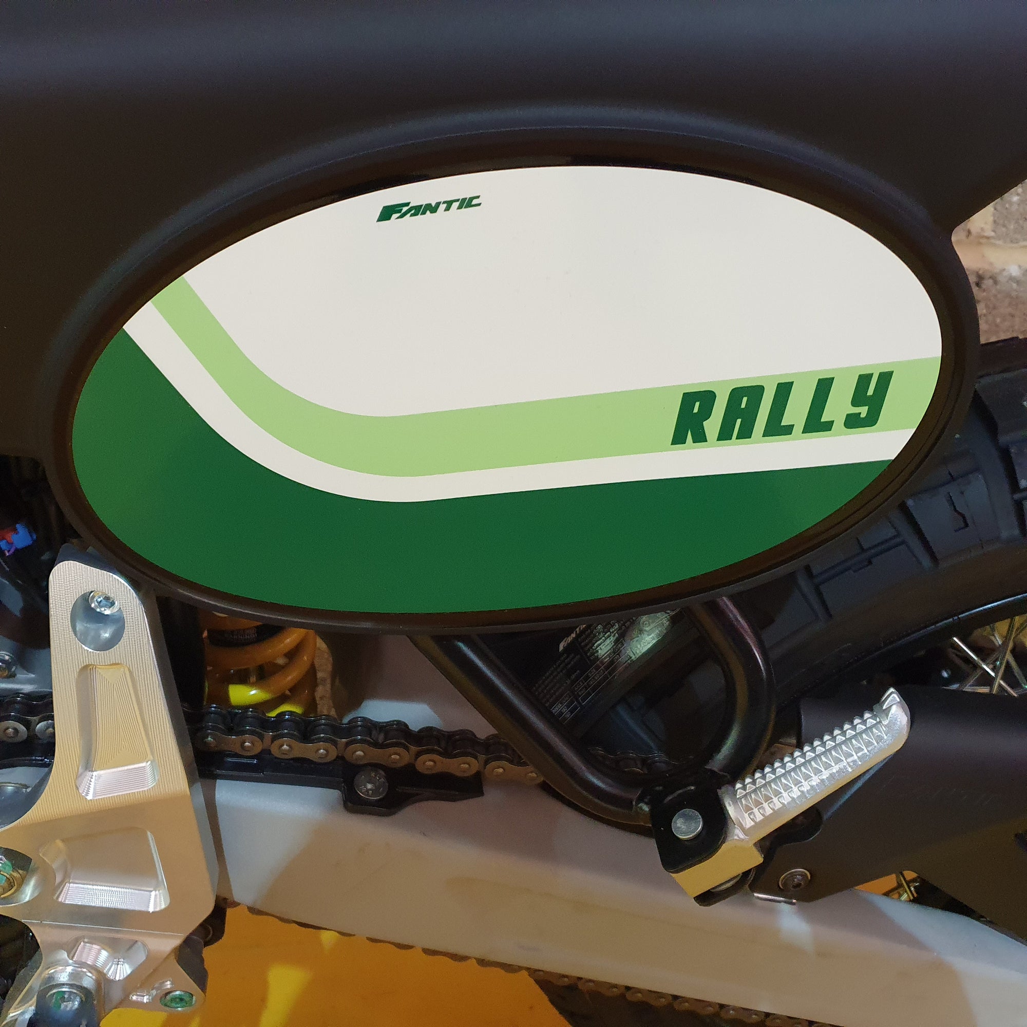 Close-up of a motorcycle with a 'Rally' label on the fuel tank.