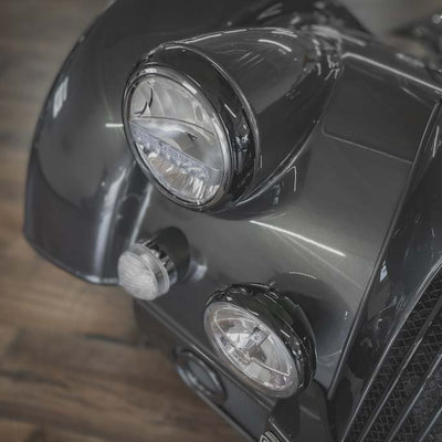 Close-up of a motorcycle's front lights on a wooden floor.