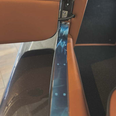 Close-up of a car door handle and window control panel.