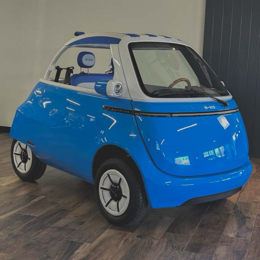 Small blue and white electric car on a wooden floor