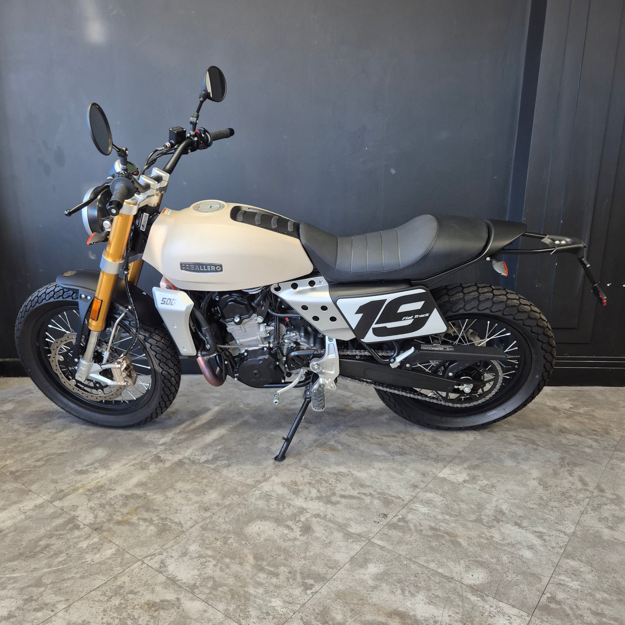 Motorcycle parked inside a garage with a gray floor.