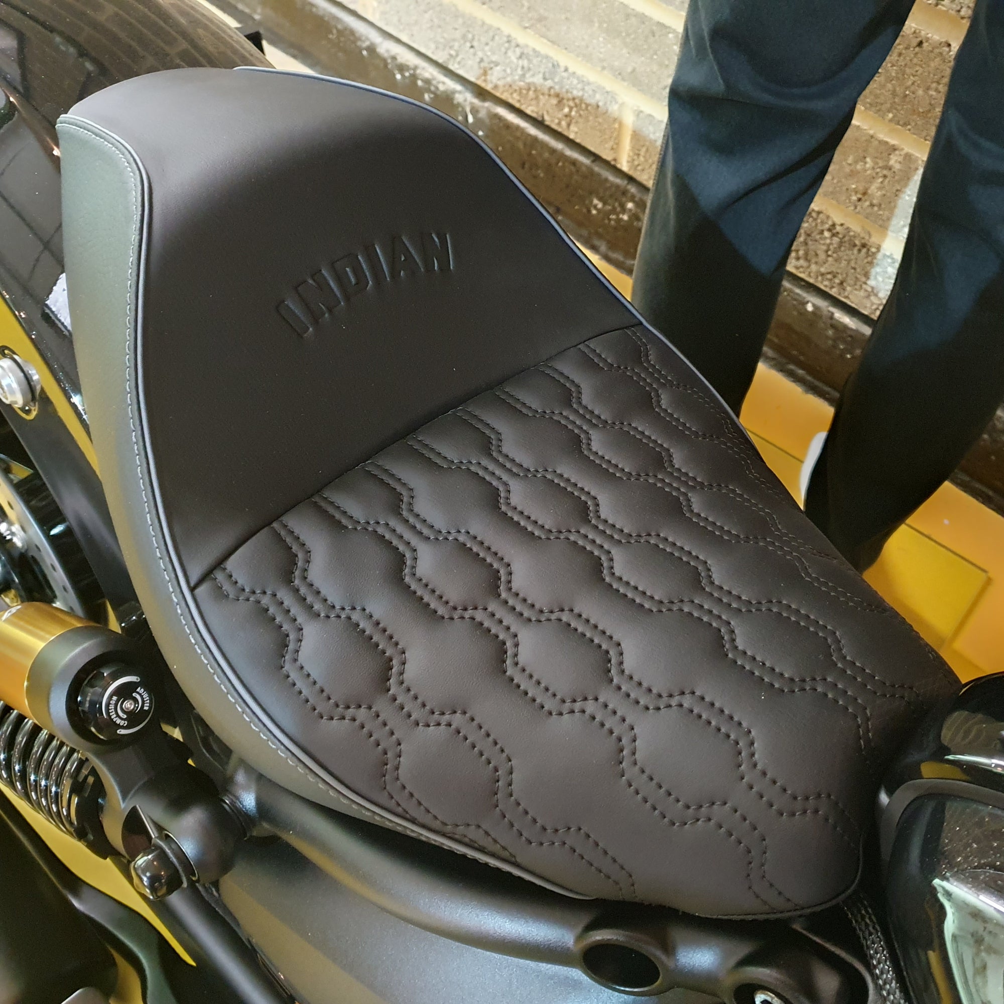 Close-up of a motorcycle seat with 'Indian' branding on a textured surface.