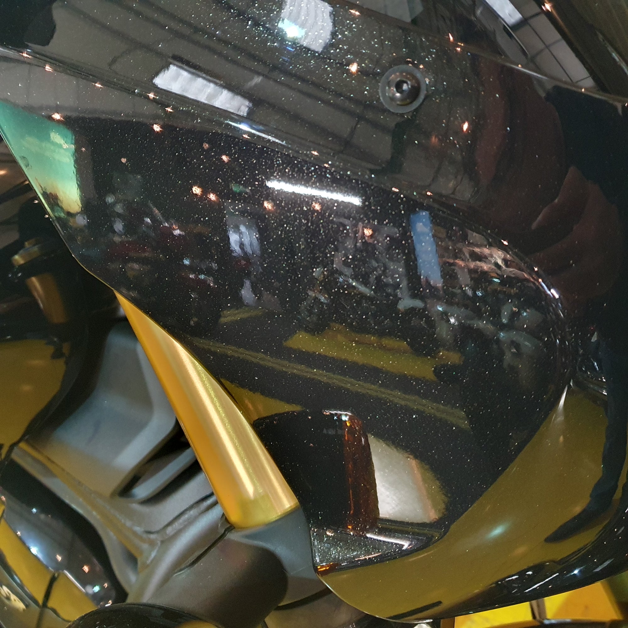 Close-up of a motorcycle's headlight and front fender with a blurred background