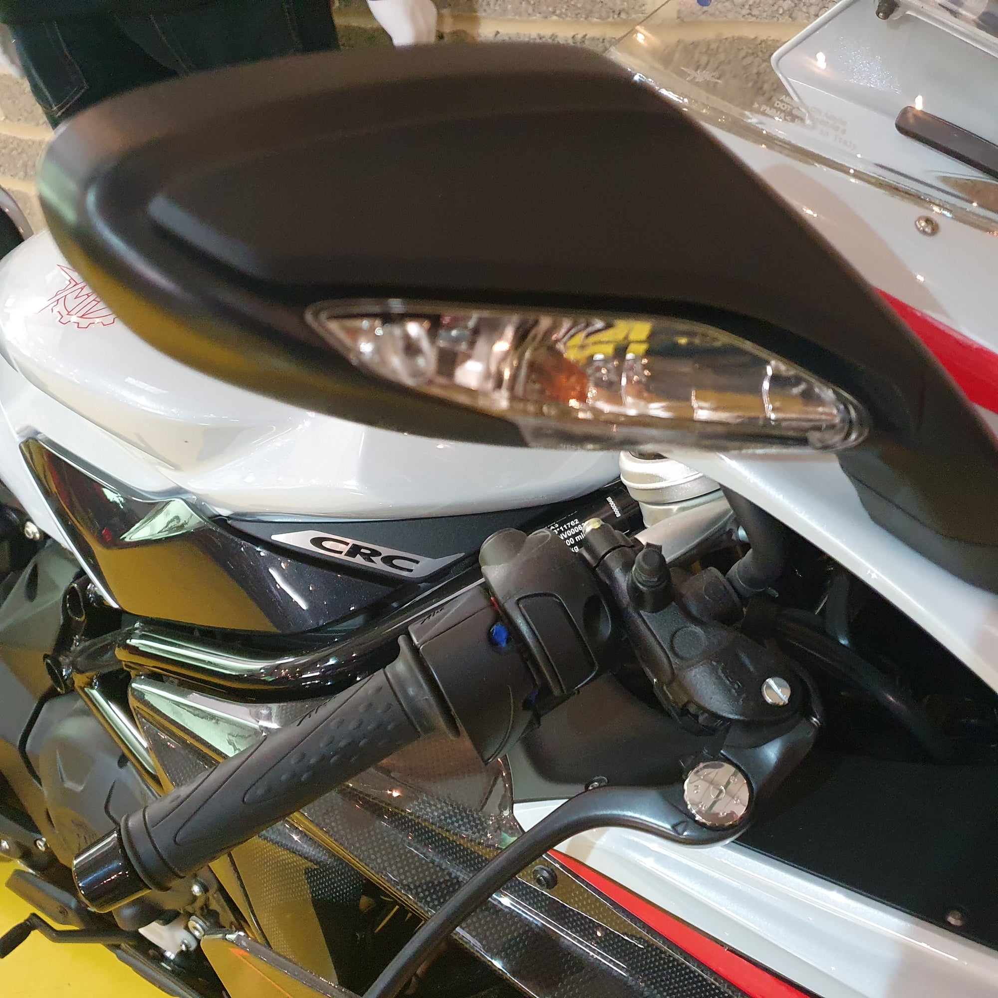 Close-up of a motorcycle handlebar with CRC branding