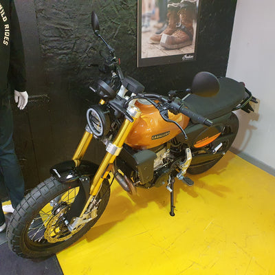 Motorcycle on display with a person partially visible on a yellow floor.