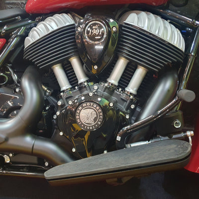 Close-up of a Indian Motorcycle V-Twin engine with polished silver and black components, featuring the Indian Motorcycle emblem on the engine cover.