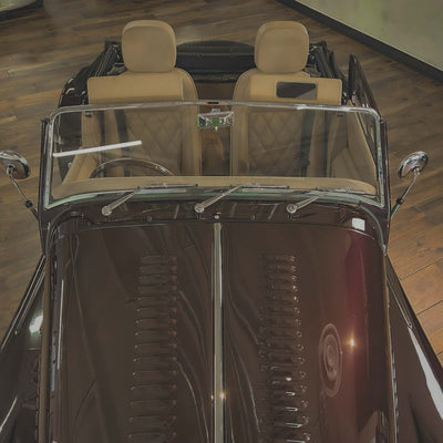 Vintage car interior with beige seats on a wooden floor.