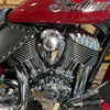 Close-up of a motorcycle engine with 'Indian' branding on a wooden floor.