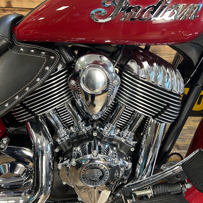 Close-up of a motorcycle engine with 'Indian' branding on a wooden floor.