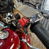 Close-up of a motorcycle handlebar with chrome and red elements.