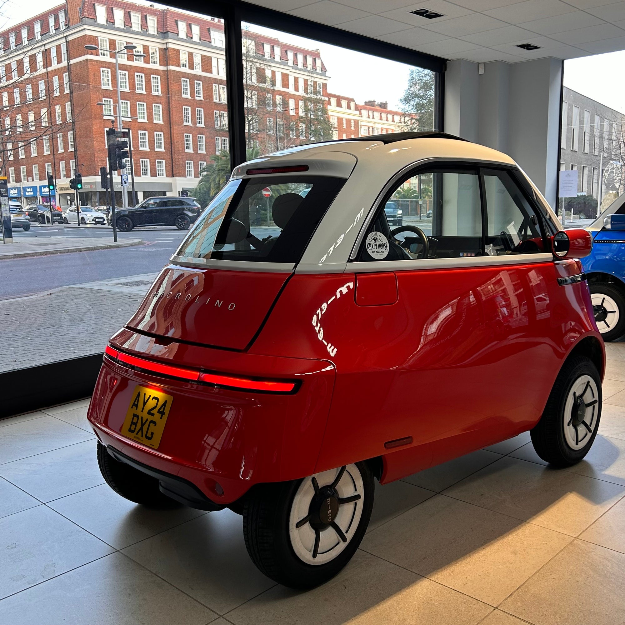 Small red car with a white top inside a showroom