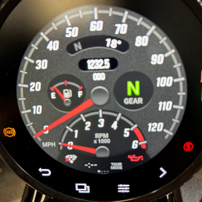 Close-up of a vehicle dashboard with speedometer and other gauges.