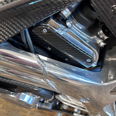 Close-up of a motorcycle engine with metallic and carbon fiber components.