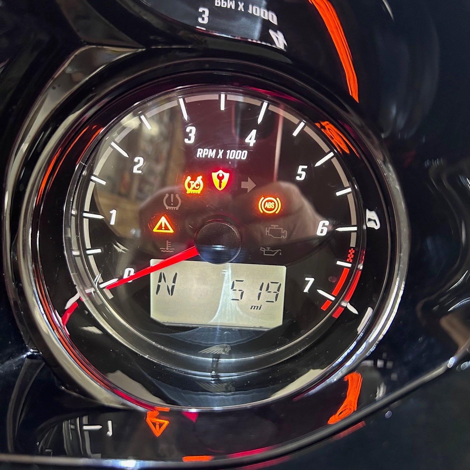 Close-up of a motorcycle dashboard with speedometer and digital display.