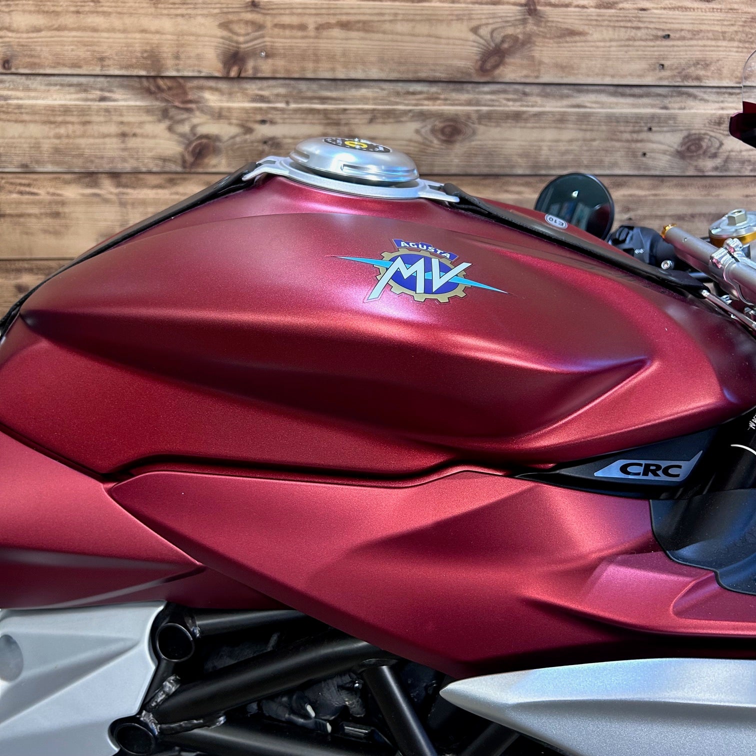 Red motorcycle with MV Agusta logo against a wooden background