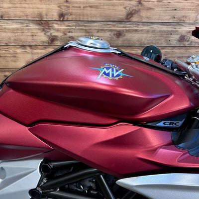 Red motorcycle with MV Agusta logo against a wooden background