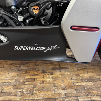 Close-up of a motorcycle with 'Superveloce MV' branding on a wooden floor.