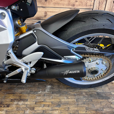 Close-up of a motorcycle with 'MV Agusta' branding on a wooden floor.