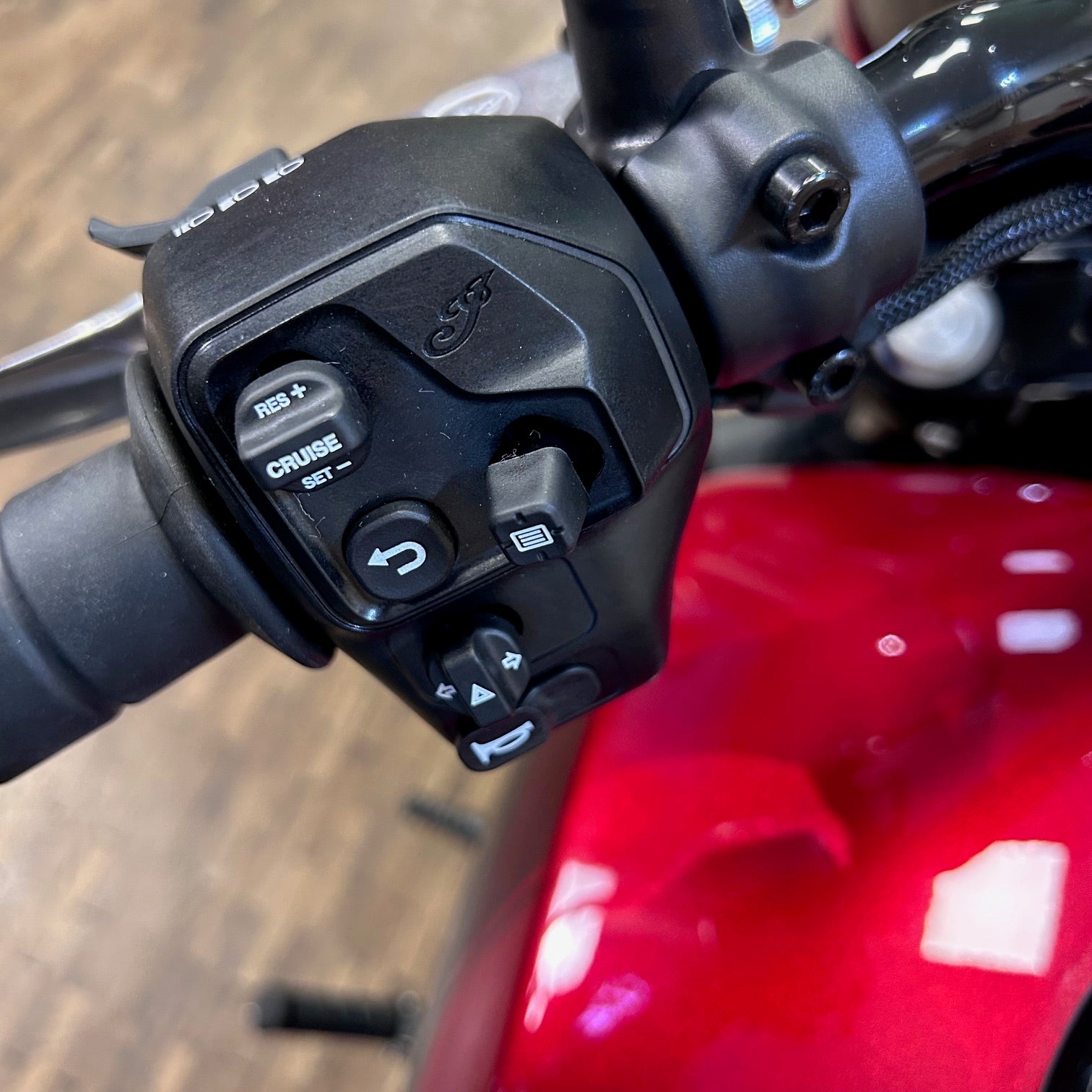 Close-up of a motorcycle handlebar with control buttons on a red motorcycle.