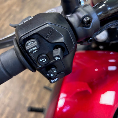 Close-up of a motorcycle handlebar with control buttons on a red motorcycle.