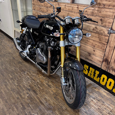 Black motorcycle with gold accents in a showroom setting