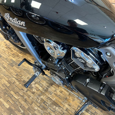 Close-up of a motorcycle with 'Indian' branding on a wooden floor.