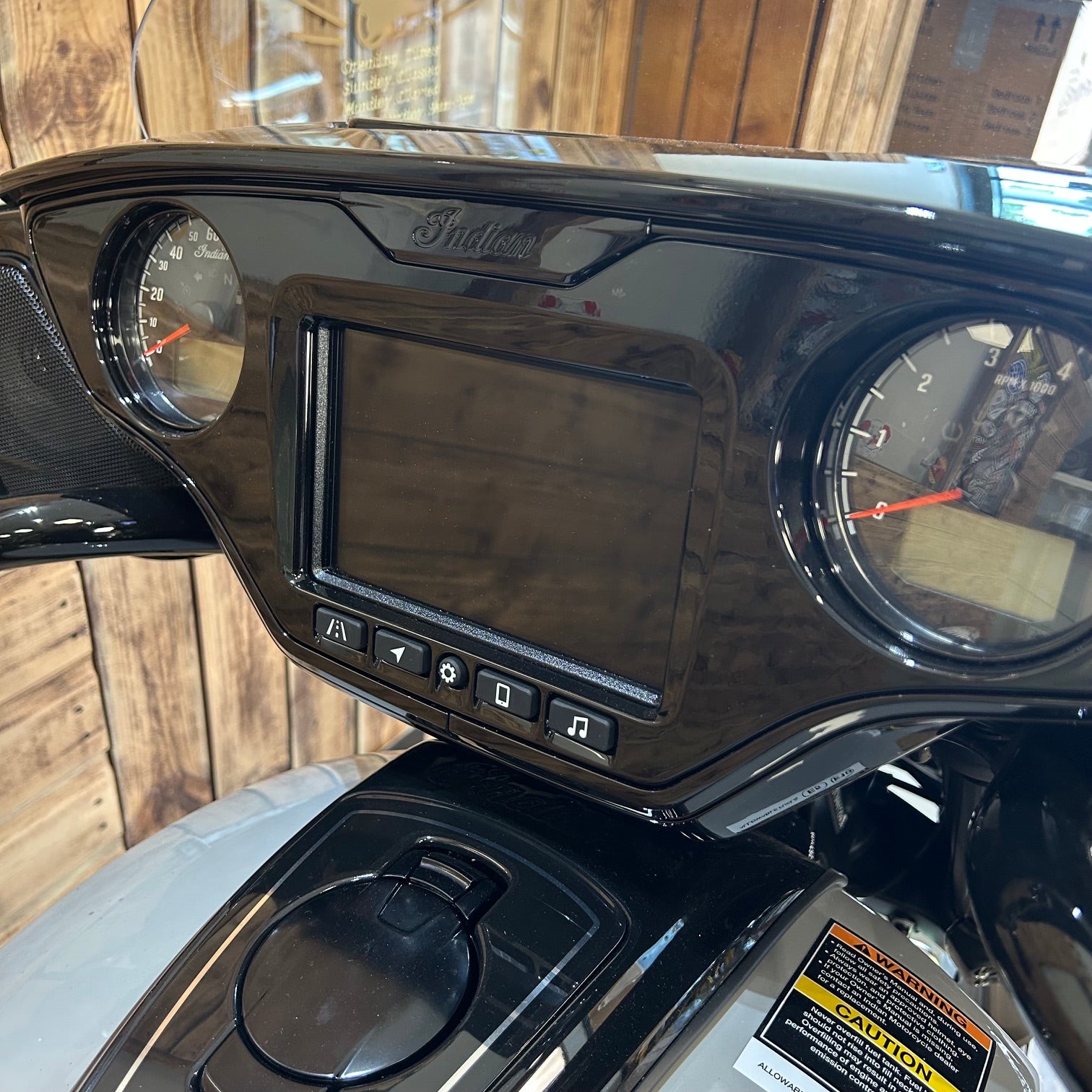 Close-up of a motorcycle dashboard with digital display and gauges.