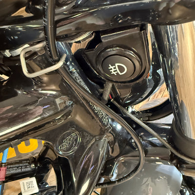 Close-up of a motorcycle ignition switch and surrounding chrome parts.