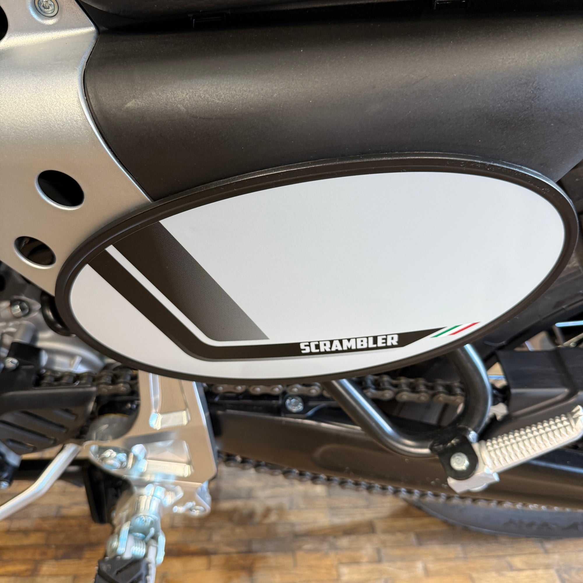 Close-up of a Fantic motorcycle's exhaust and 'Scrambler'