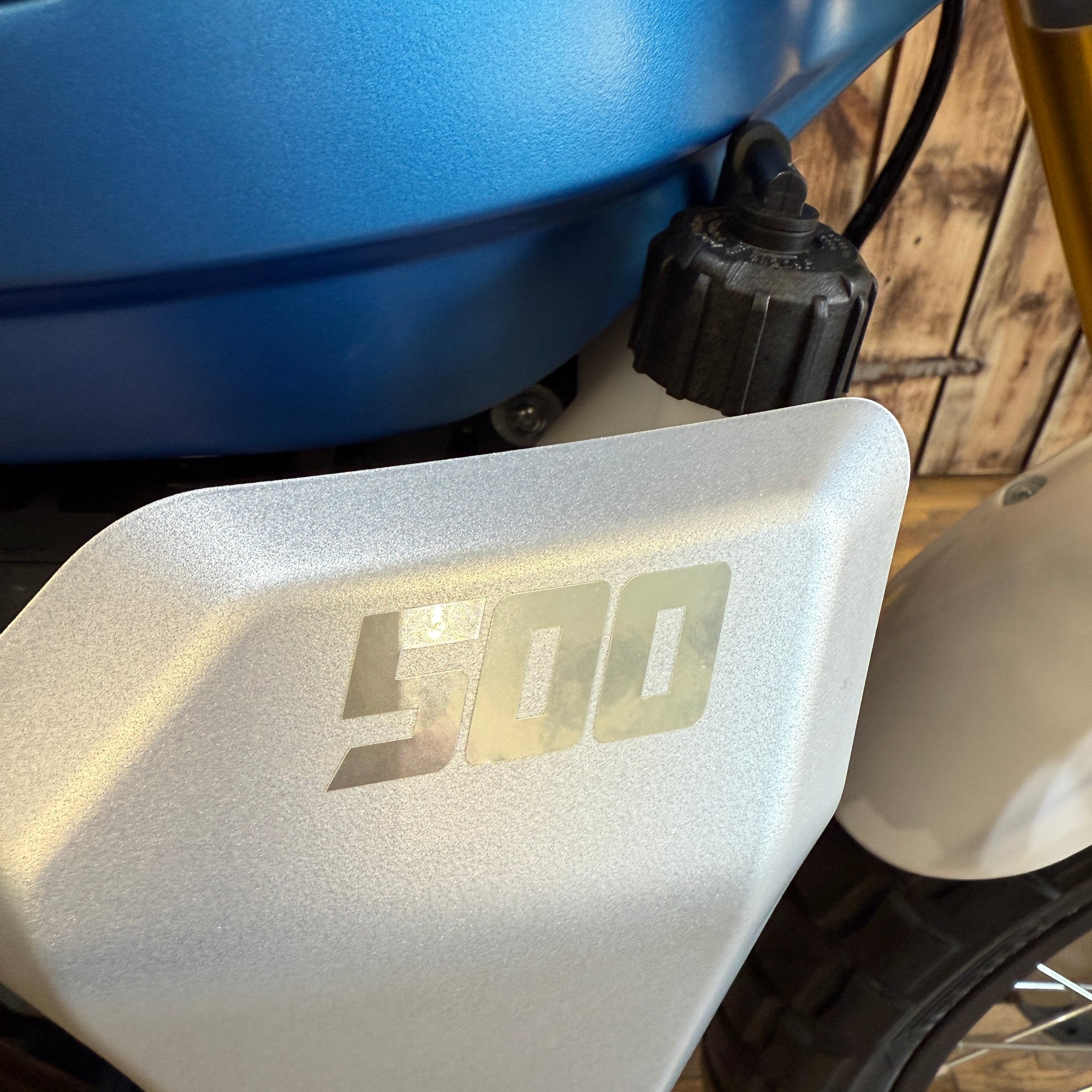 Close-up of a motorcycle with '500' branding on a wooden background