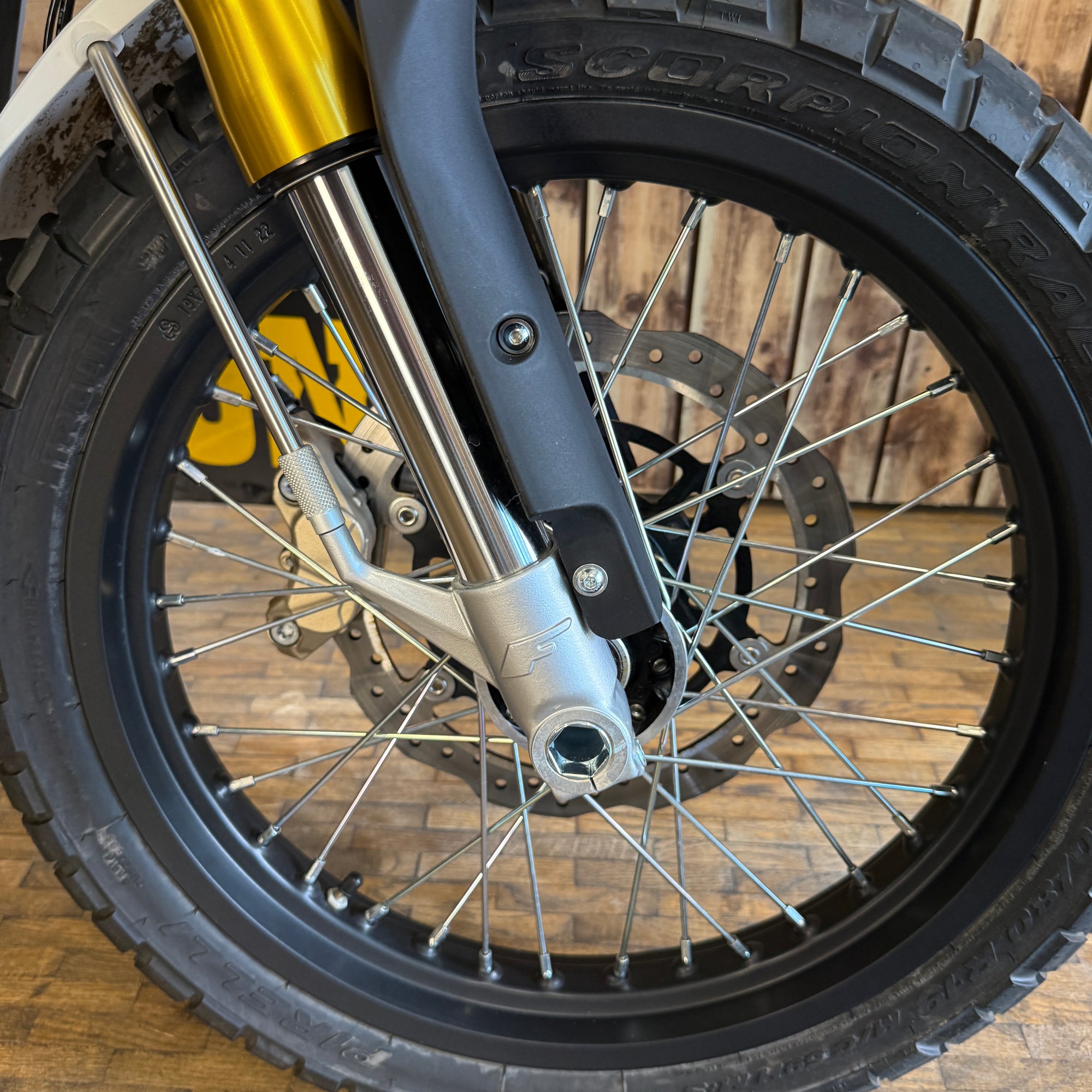 Close-up of a motorcycle wheel with a wooden background