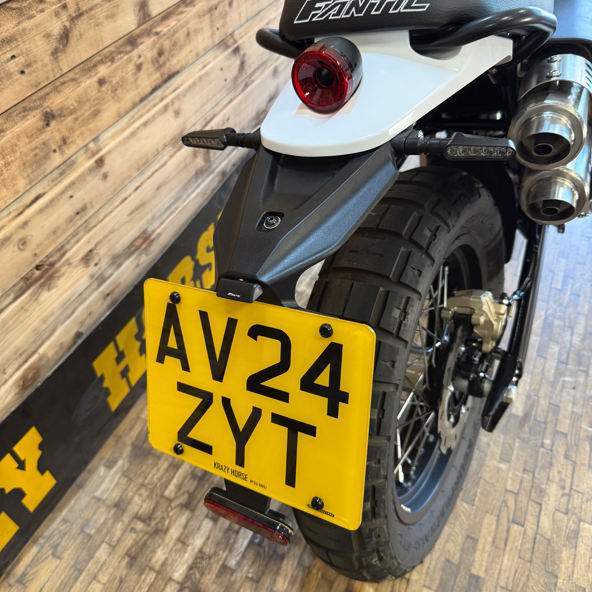 Motorcycle with a yellow license plate on a wooden floor