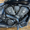 Close-up of a motorcycle engine with visible branding on a wooden floor.