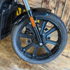 Close-up of a motorcycle wheel with a wooden floor background