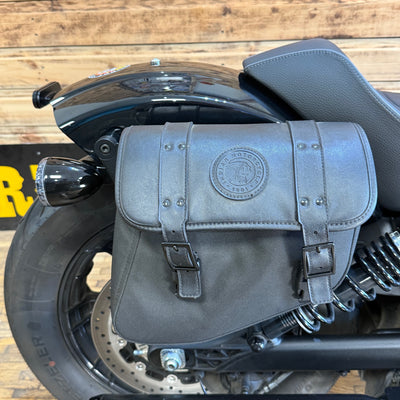 Gray leather saddlebag on a motorcycle with a wooden floor background