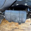 Black leather motorcycle saddlebag with brand logo on a wooden floor