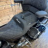 Close-up of a motorcycle seat with 'Indian' branding on a wooden floor.